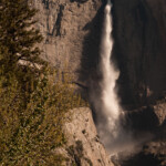The sun has just started to hit the waterfall. The dark areas just to the left of the water are actually shadows cast by the water as it falls.